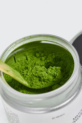 אבקת מאצה טקסית של מותג matcha ready, 30 גרם, מונחת על משטח בהיר, עם תווית ומיכל שקוף.